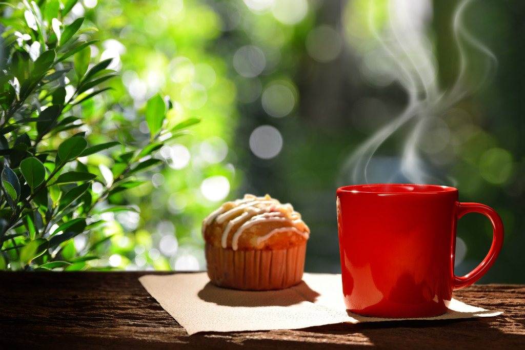 Morning cup of coffee with cup cake in the garden